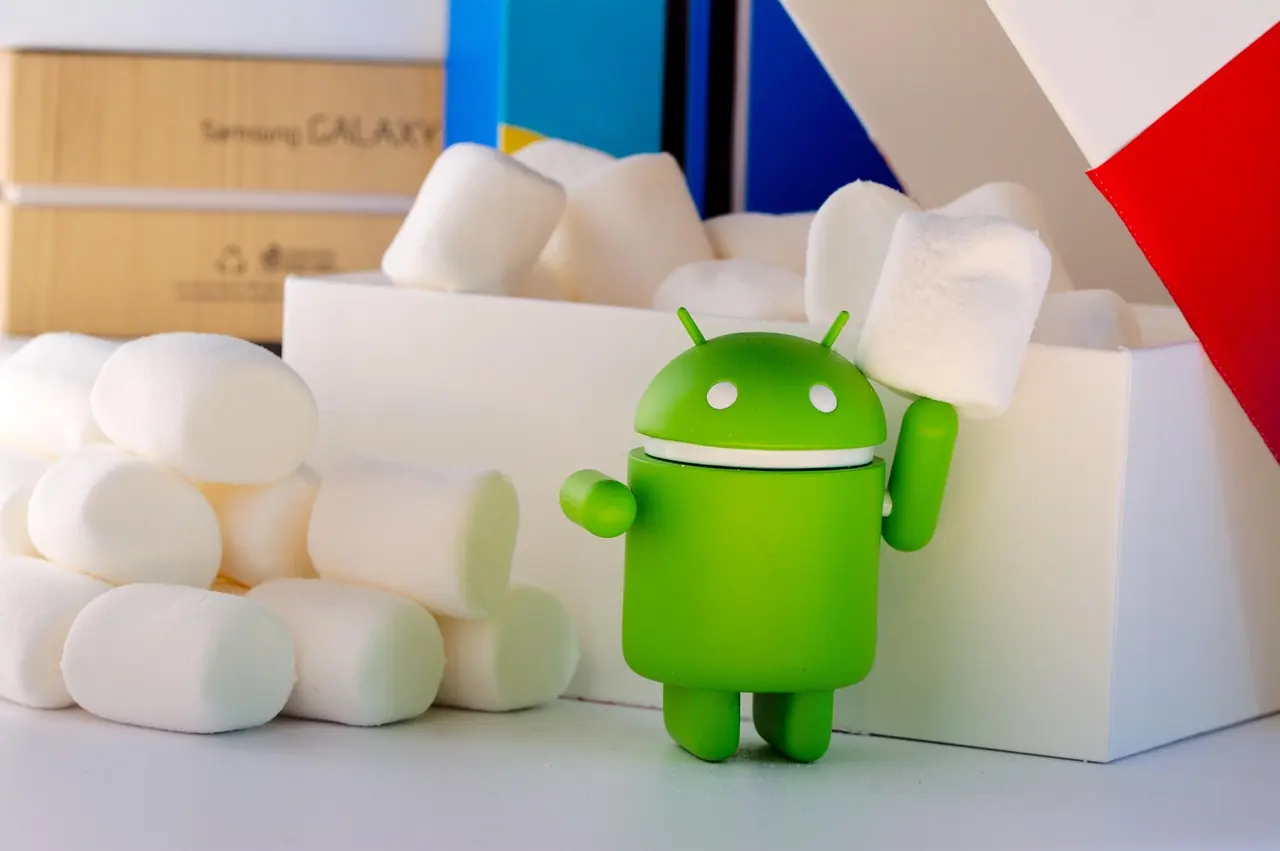The green Android robot mascot figurine beside white marshmallows and a Samsung Galaxy box