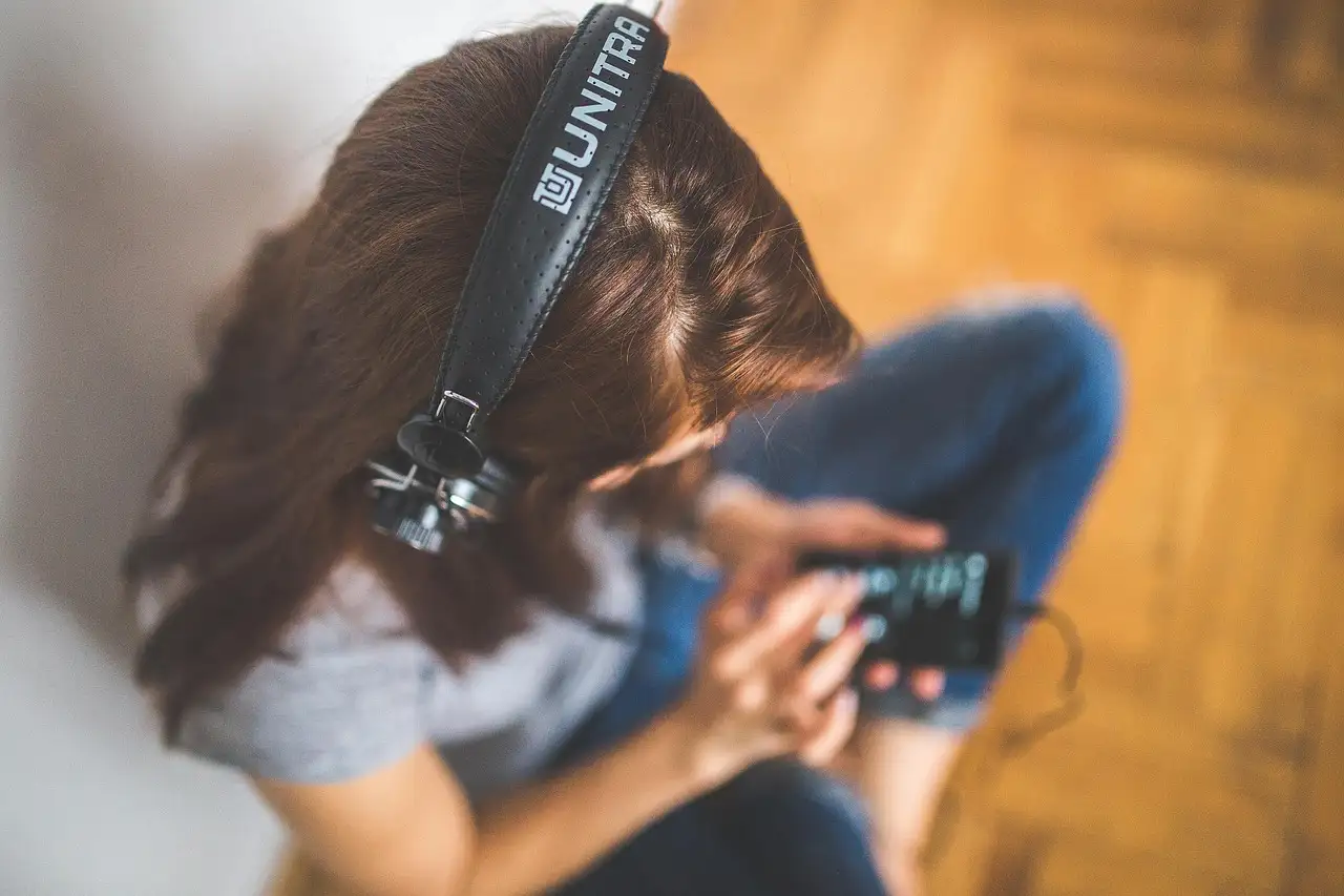 A woman wearing headphones and listening to music