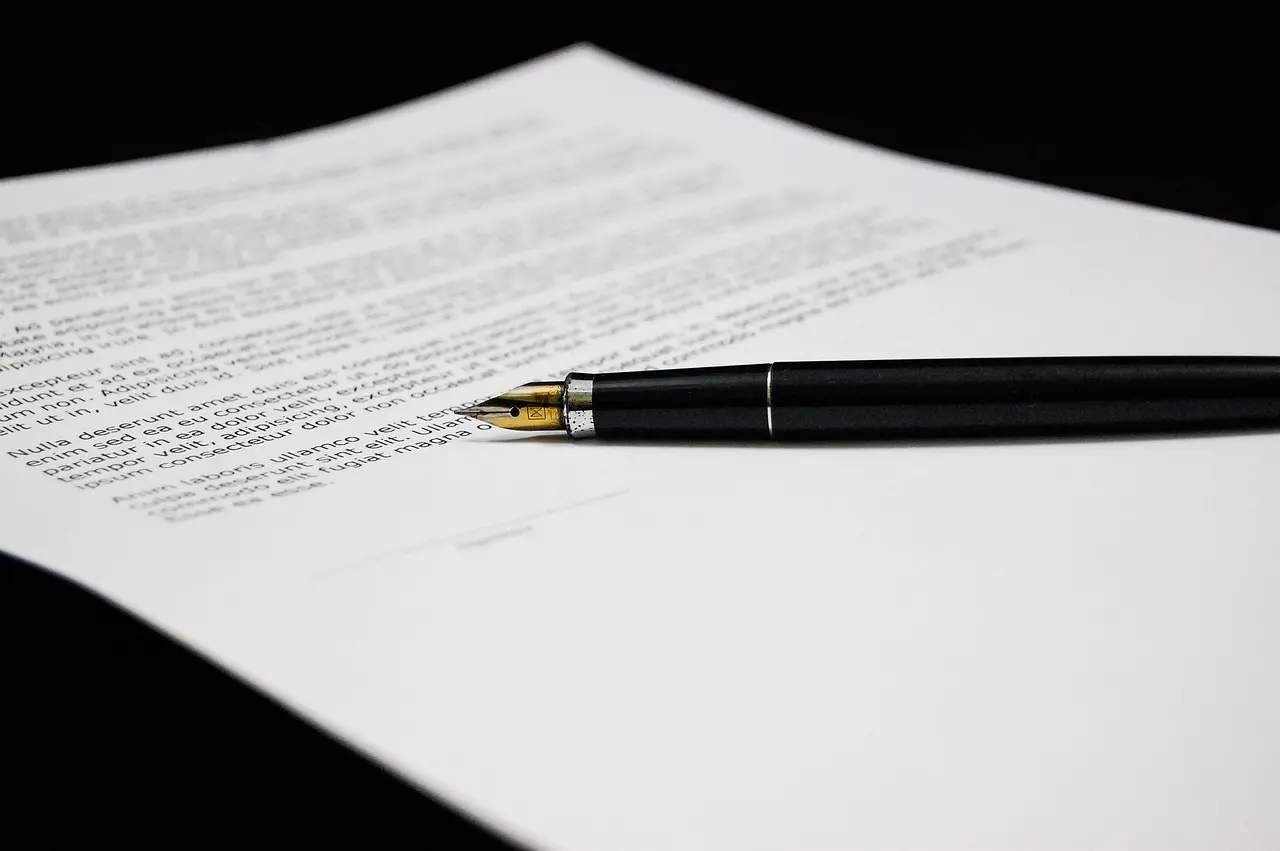A hand signing a printed document