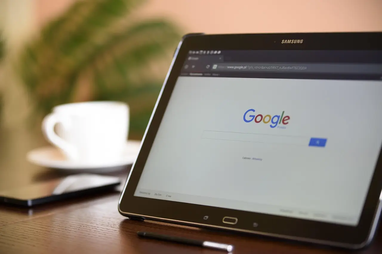 Close-up of a hand tapping the three-dot Chrome menu on a laptop, with a browser privacy settings panel visible on screen.