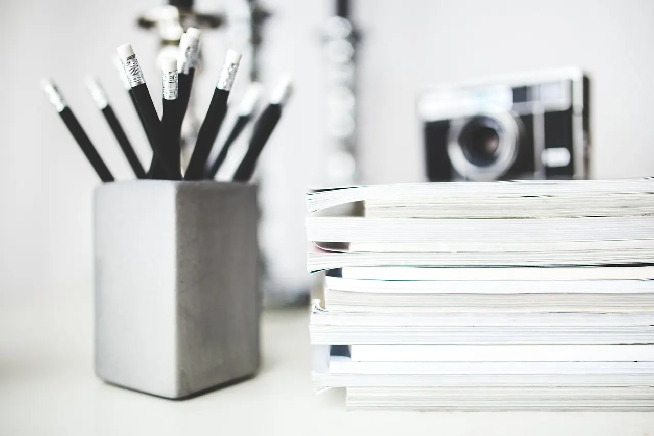 A tidy stack of notebooks and pencils on a desk