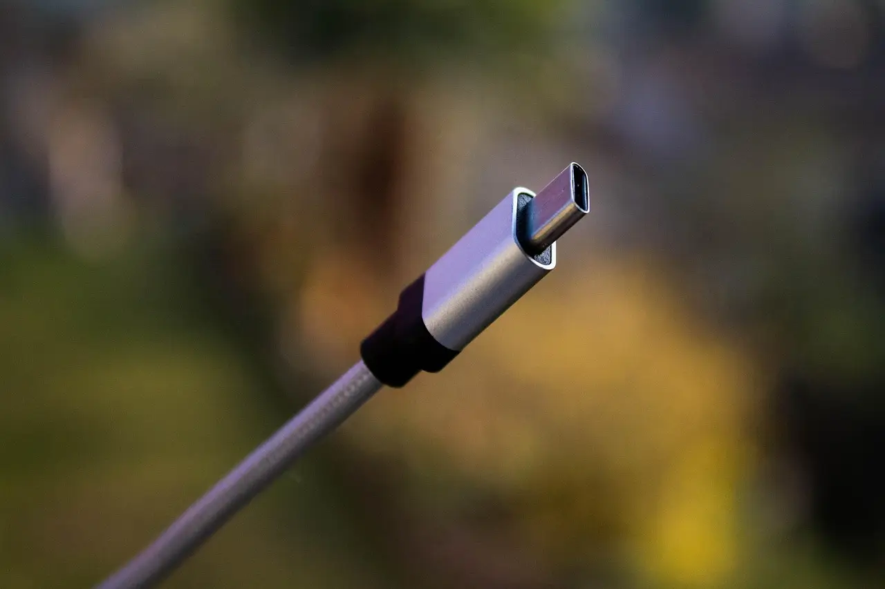 A grey braided USB-C charging cable coiled on a light surface