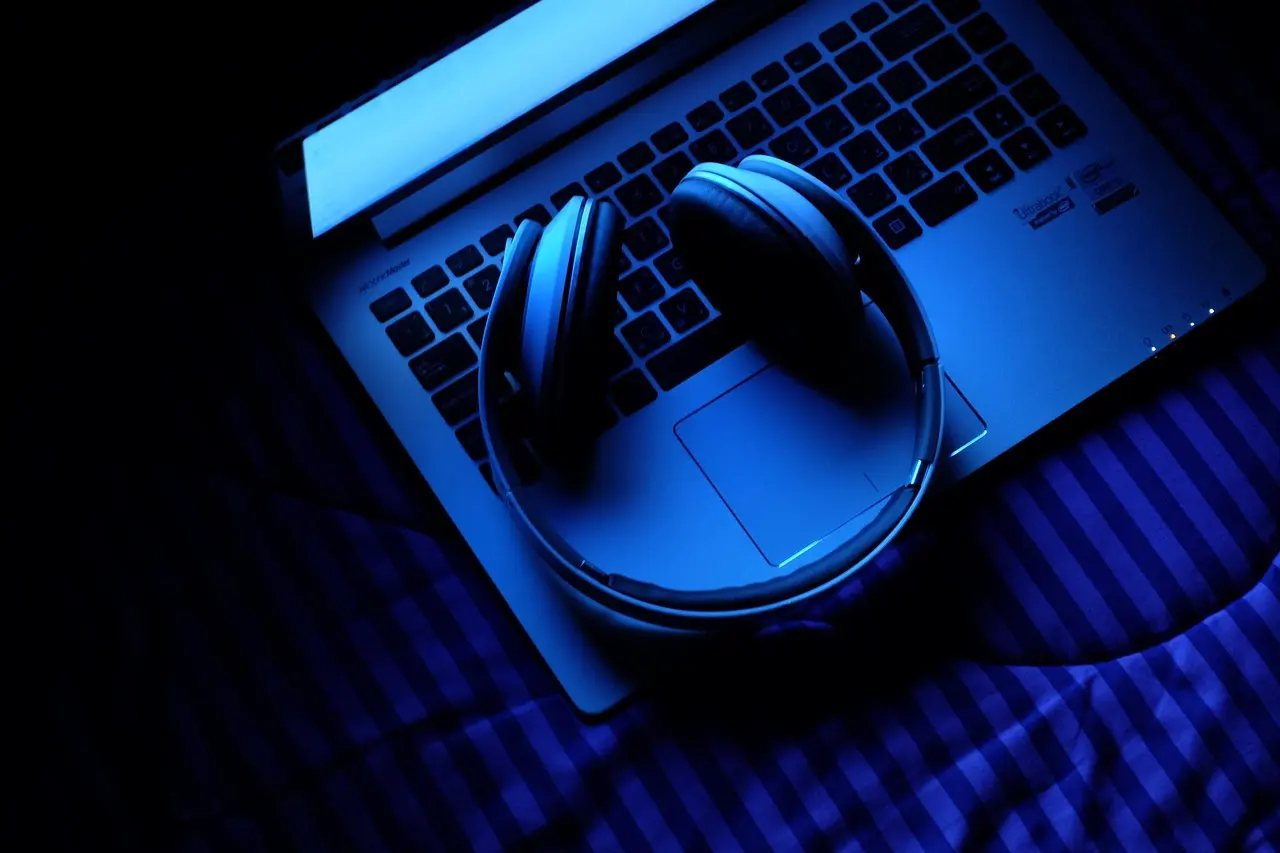 A laptop on a desk with headphones