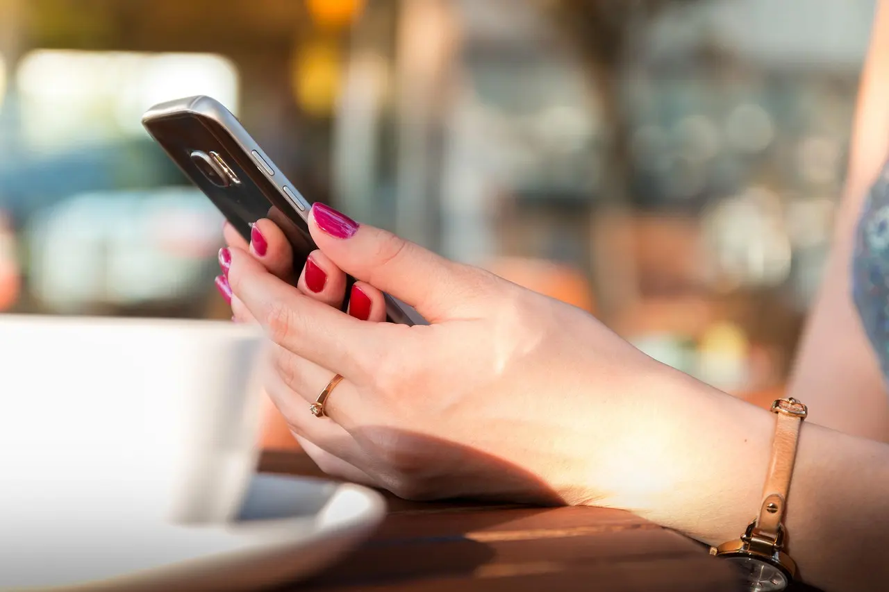 Two hands holding a smartphone while chatting