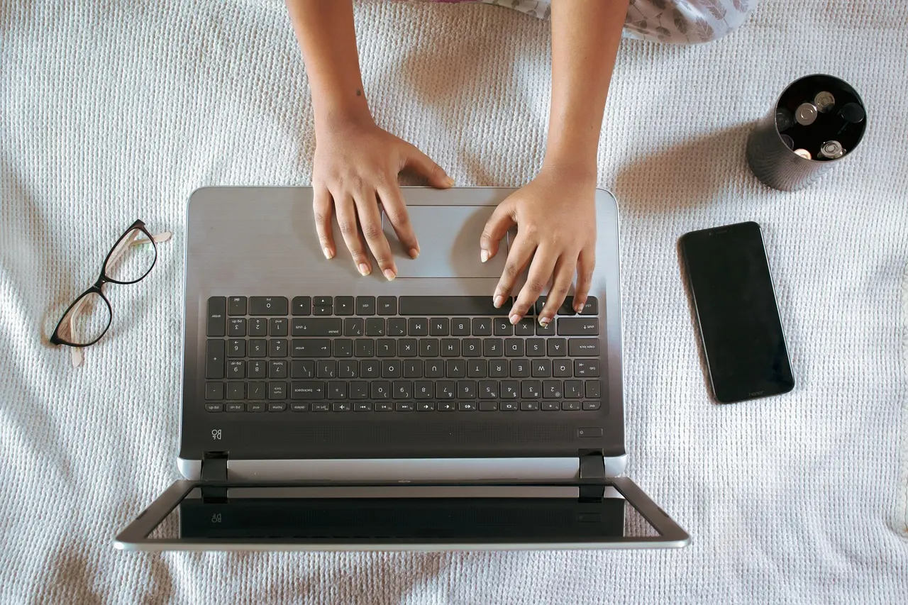 A laptop and gadgets laid out on a desk