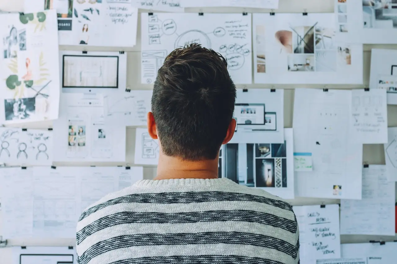 People working in an office beside a whiteboard