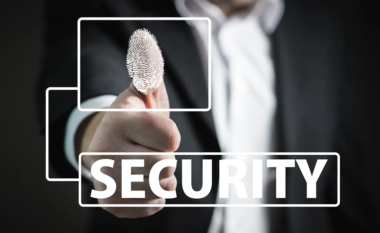 A thumb pressing a fingerprint reader to unlock a device.