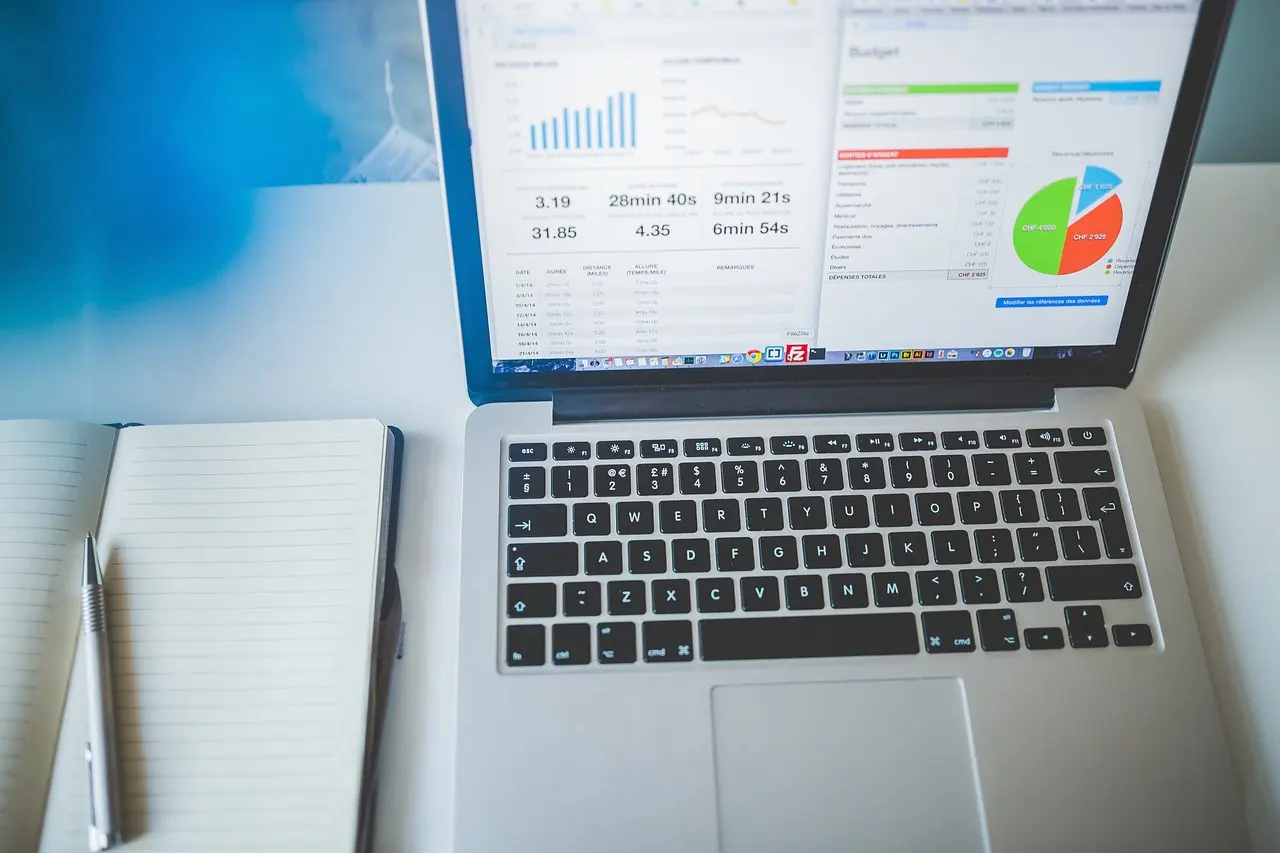 A laptop showing business charts on a desk