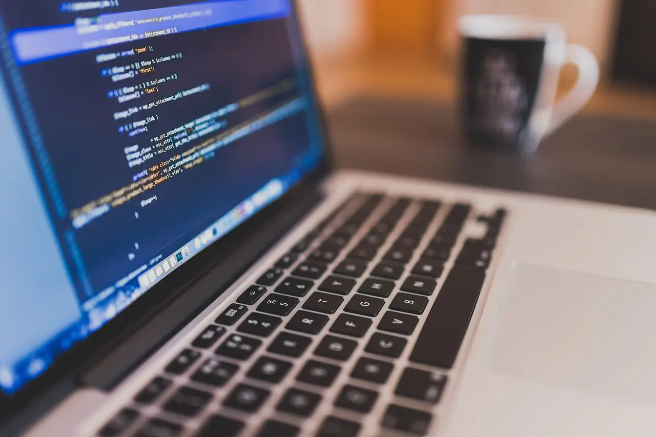 A laptop on a desk showing code.