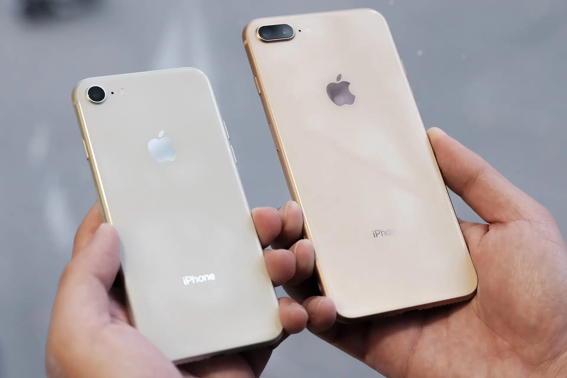 iPhone 8 in silver and iPhone 8 Plus, both holding in the hand