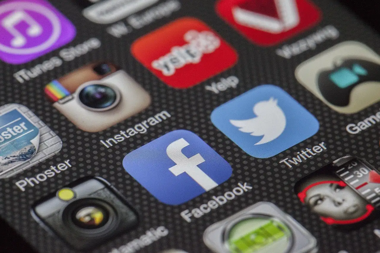 Close-up of a phone home screen with the Facebook, Twitter, Instagram, and Yelp app icons