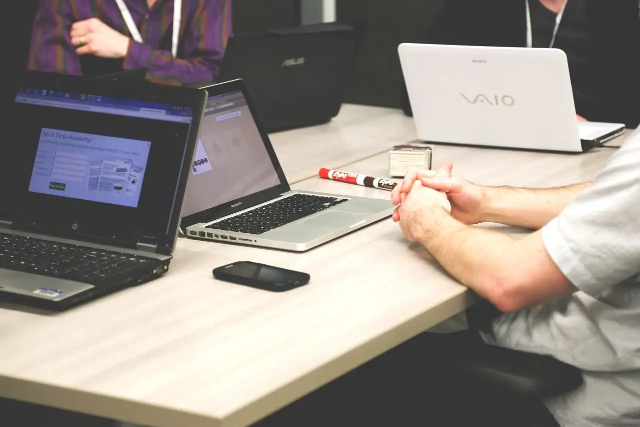 Open laptops on a table during a meeting.